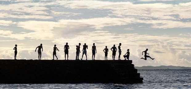 'Jump! Porto da Barra, Salvador. Every afternoon, youngsters gather on the breakwater protecting the Porto da Barra beach in Salvador to swim and dive into the warm Atlantic waters.'