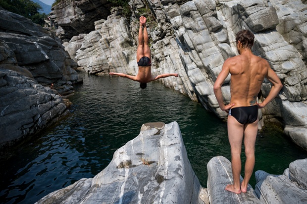 Divers warm up by diving from a three-metre rock prior to the Cliff Diving European Championships in Ponte Brolla, Switzerland.