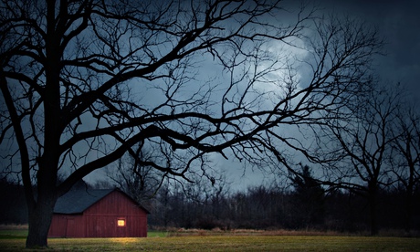 Illuminated barn in rural landscape