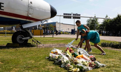 Two local children lay bouquets of flowers on the grass in front of a Dutch airplane in Eindhoven.