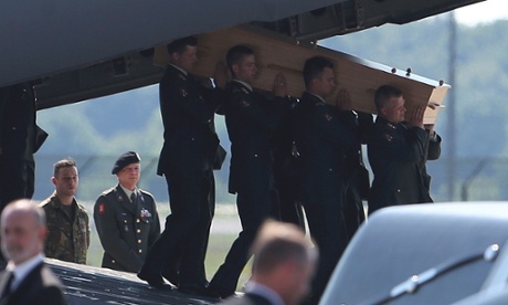 A coffin of one of the victims of Malaysia Airlines MH17 downed over rebel-held territory in eastern Ukraine, is carried from an aircraft during a national reception ceremony at Eindhoven.