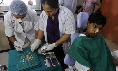 Ashik Gavai beside the 232 teeth surgeons removed from his jaw.