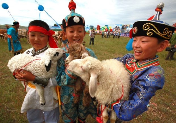 Young Mongolians with their pets during the annual Mongolian Nadaam Festival in Chifeng, Mongolia.  The festival features various Mongolian ethnic groups, nomads and wrestlers in traditional garb.
