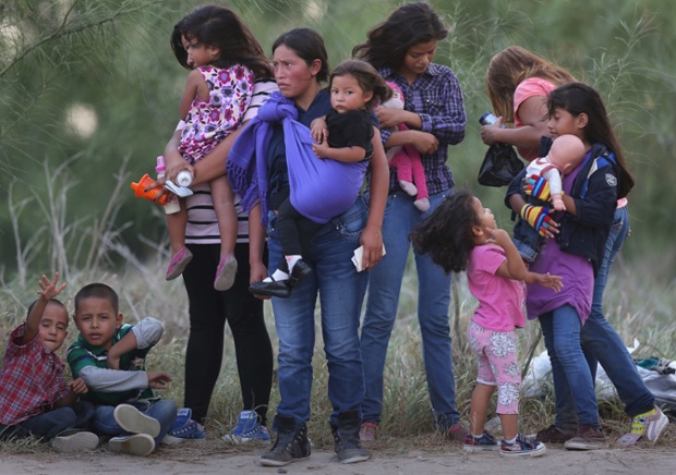 Central American immigrants await transportation to a US Border Patrol processing centre after crossing the Rio Grande from Mexico into Texas. 