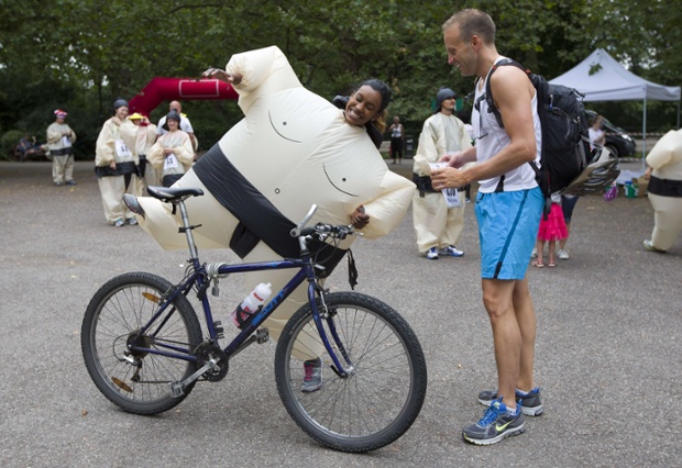 London, UK: A participant attempts to mount a bike in an inflated suit before taking part in The Sumo Run in Battersea Park.