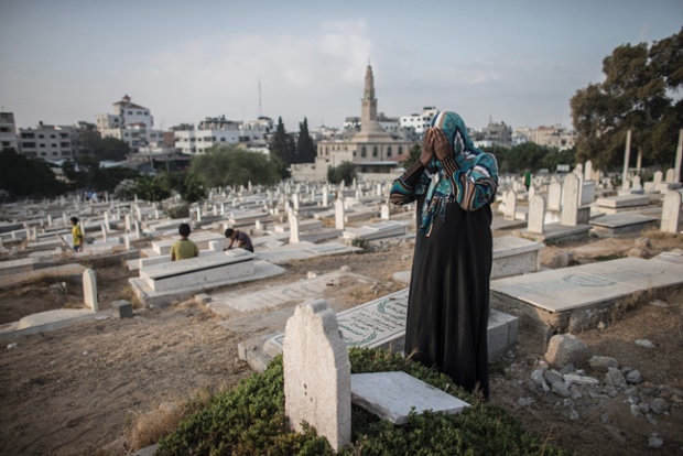 Gaza City, Gaza Strip: A Palestinian woman mourns by her relative's grave.