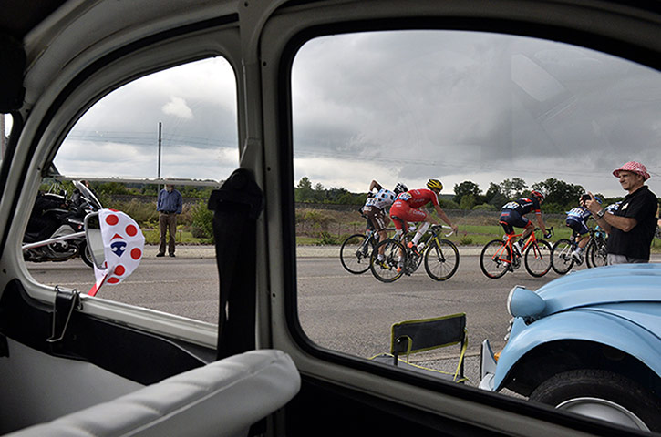 Watching the TDF2014: Cyclists riding is seen through the windscreen of a Citroen 2CV during 18th
