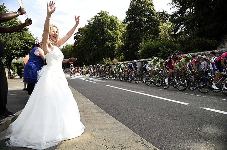 Watching the TDF2014: A woman wearing a bride dress waves at the cyclists on the 21st Stage.