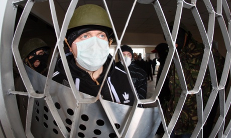 Masked pro-Russia fighters stand guard inside the regional police building in Gorlovka
