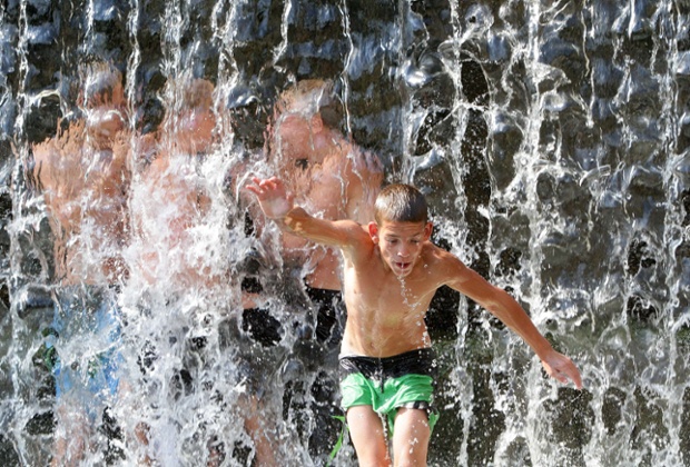 Boys jump from a bridge into the waterfall in Vilnius trying to refresh themselves as it is one of the hottest days this summer in Lithuania, with temperatures rising up to 33C, in Vilnius, Lithuania.