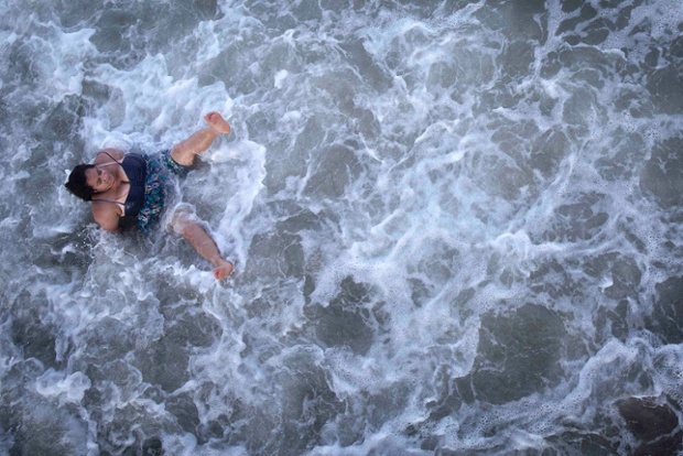 A woman gets knocked over in the surf on Coney Island in Brooklyn, New York