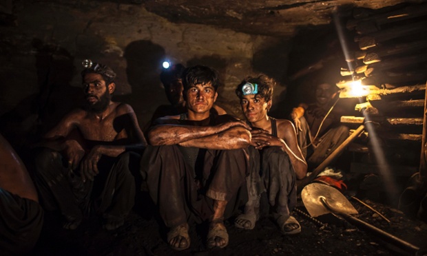Miners pose for a photograph at the coal face inside a mine in Choa Saidan Shah, Punjab province