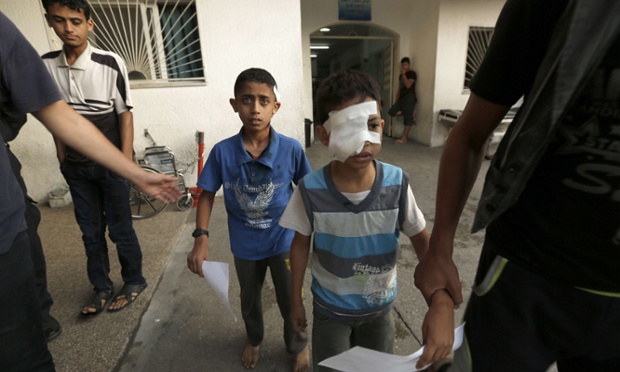 Two wounded Palestinian children taking shelter at a UN school receive treatment