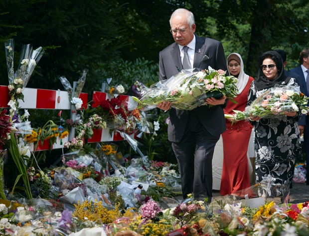 Malaysian Prime Minister Najib Razak and his wife Datin Sri Rosmah Mansor, lay flowers among other floral tributes, outside the military barracks where forensic experts are working to identify bodies and human remains recovered from the wreckage of Flight MH17, in the central city of Hilversum, Netherlands.