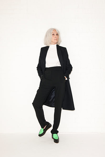 All Ages androgynous: white crepe rollneck black coat black trousers green black shoes
