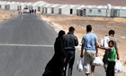 Syrian refugee family walks towards the new Syrian camp of Azraq