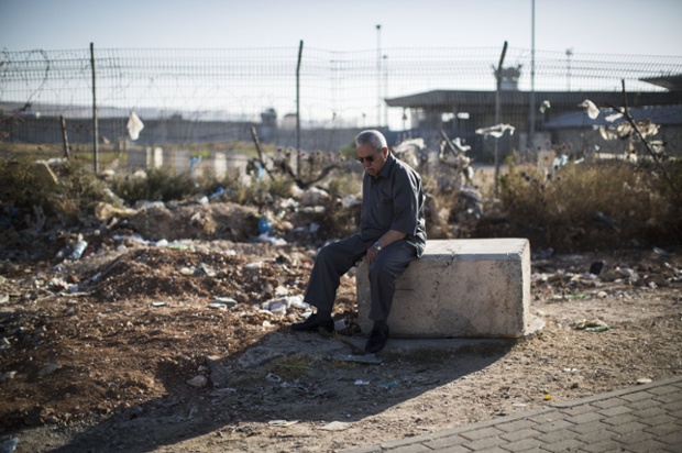 A Palestinian Muslim waits for a bus near Ramallah, West Bank