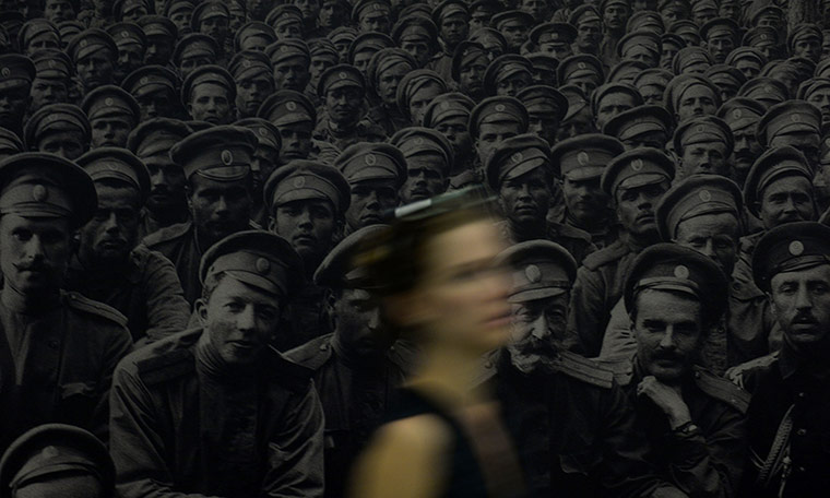 20 photos: A young woman walks past a photograph of Russian soldiers