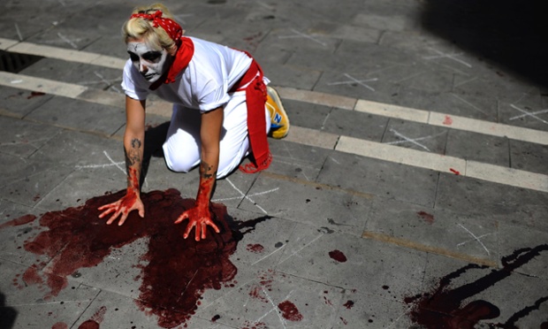 Pamplona, Spain: An anti-bullfighting protester wearing a traditional red scarf takes part in a demonstration during the annual San Fermin festival.