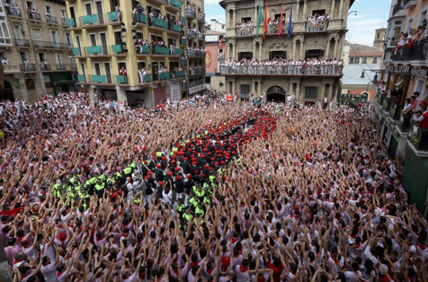 Pamplona, Spain: Revellers wave their arms as the band plays during the opening and the firing of the 'Chupinazo' rocket at the start of the San Fermin Festival.