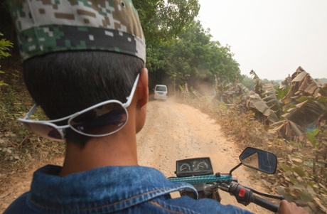 A motorcycle smuggles a passenger from China to Burma through rubber plantations and jungle, avoiding the official Chinese border crossing, outside MongLa, Shan State Special Region Four, Burma, 04 April 2014.