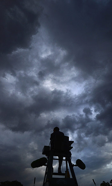 Wimbledon Best: An umpire on Court 12 is silhouetted by rainclouds on the first day