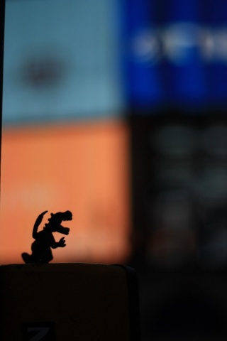 a silhouette of a toy dinosaur in front of piccadilly circus 