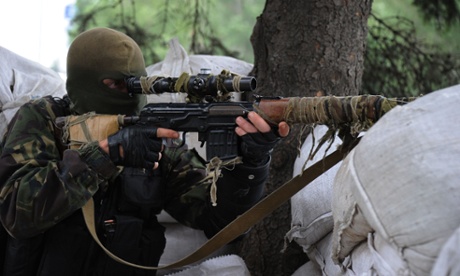 Pro-Russian militant of the Vostok batallion looks through the scope of his rifle as he guards a checkpoint on 8 July, 2014 in Donetsk, eastern Ukraine.
