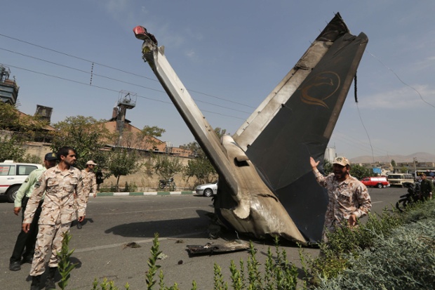 Tehran, Iran: A member of the Iranian Revolutionary Guard stands next to the remains of a civilian airliner that crashed near Mehrabad.