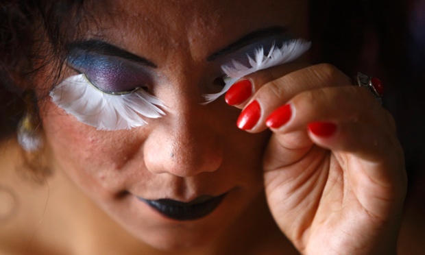 A reveller gets ready to take part in a pride parade marking the Gaijatra Festival in Kathmandu