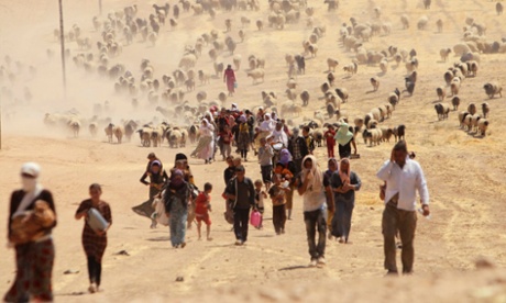 Displaced people from the minority Yazidi sect, fleeing violence from forces loyal to the Islamic State in Sinjar town, walk towards the Syrian border, on the outskirts of Sinjar mountain, near the Syrian border town of Elierbeh of Al-Hasakah Governorate.