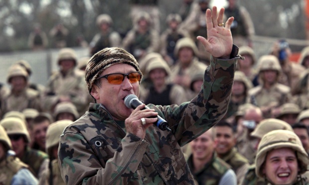 Comedian Robin Williams entertains a cheering crowd of US army troops at Baghdad airport in 2003.