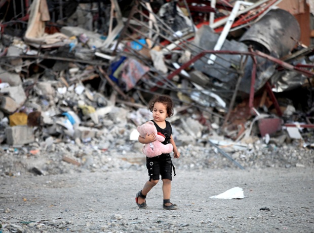 A Palestinian girl walks in front of houses, which were destroyed in an Israeli offensive in Gaza.