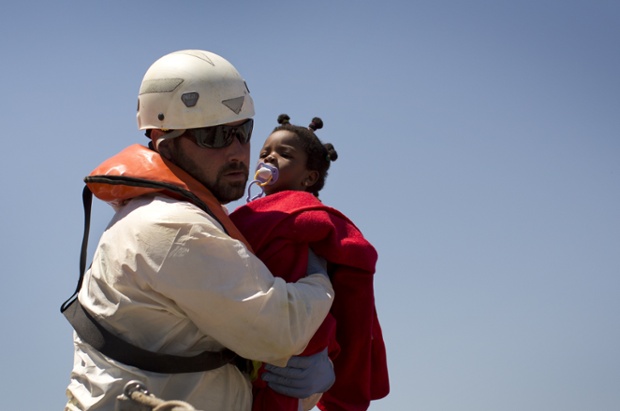 A rescue worker holds a young migrant girl after she was rescued by a Spanish coast guard vessel in the port of Tarifa, Spain. Spain's coast guard said it picked up 710 sub-Saharan Africans who were crossing the Strait of Gibraltar in 12 small boats.
