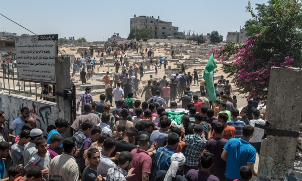 Crowds carry Rahed Taysir al-Hom to be buried next to his brother in the Gaza cemetery of Jabaliya.