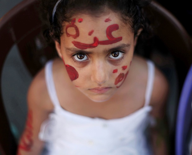 A girl with a painted face watches a marriage ceremony at a UN centre for Palestinian refugees at Al-Shati Camp in Gaza