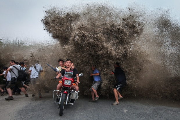 Wash out: people scramble out of the way to avoid a high wave from Qiantang River in Hangzhou, China