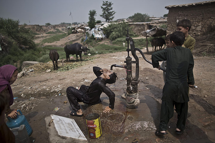20 PHOTOS: A youth cools off under a hand pump during a heatwave in Pakistan