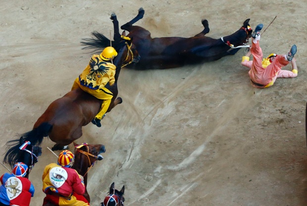A horse and jockey from the Valdimontone parish, fall at the San Martino curve during the Palio of Siena horse race.
