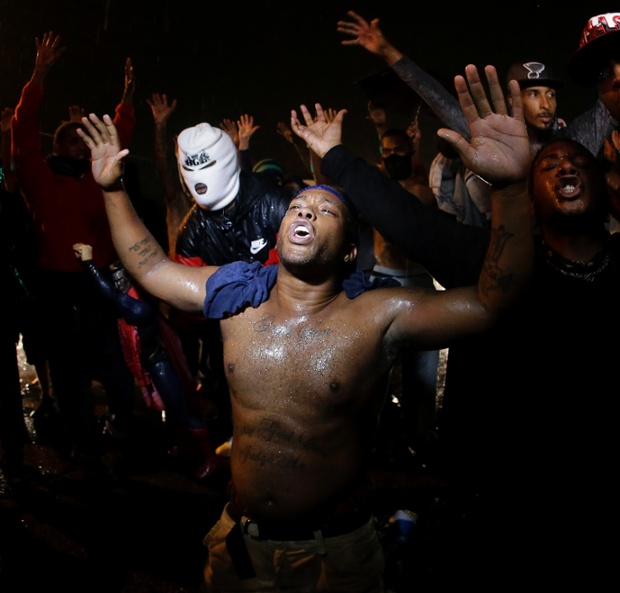 People defy a curfew and continue to protest over the shooting of teenager Michael Brown in Ferguson, a suburb of St Louis.