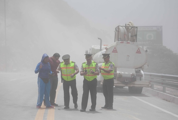 Police close the Pan-American highway to traffic as dust spreads after an earthquake struck Quito, Ecuador's capital.