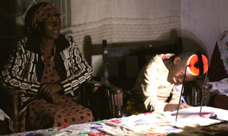 boy studies using solar-powered lamp