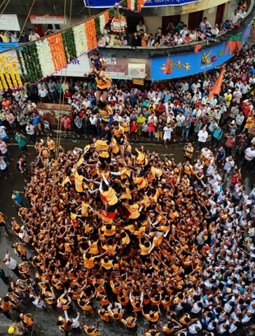 People form a human pyramid to break the Dahi handi, an earthen pot filled with curd in Mumbai, India