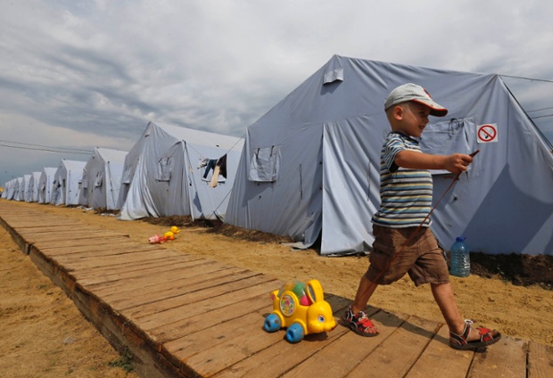 A four year old Alexander walks with a toy at a temporary tent camp set up for Ukrainian refugees outside Donetsk, located in Russia's Rostov region near the Russian-Ukrainian border.