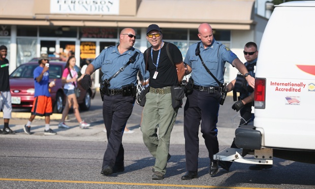 Getty Images staff photographer Scott Olson is placed into a paddy wagon after being arrested by police as he covers the demonstration following the shooting death of Michael Brown on August 18, 2014 in Ferguson, Missouri. Protesters have been vocal asking for justice in the shooting death of Michael Brown by a Ferguson police officer on August 9th.