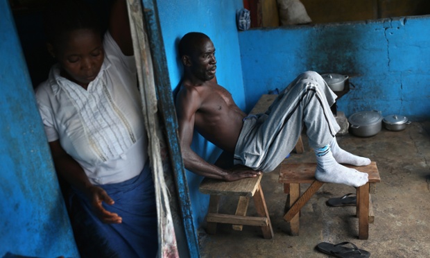 A man who was showing symptoms of possible Ebola listens as UNICEF health workers speak about Ebola prevention in New Kru Town, Liberia.