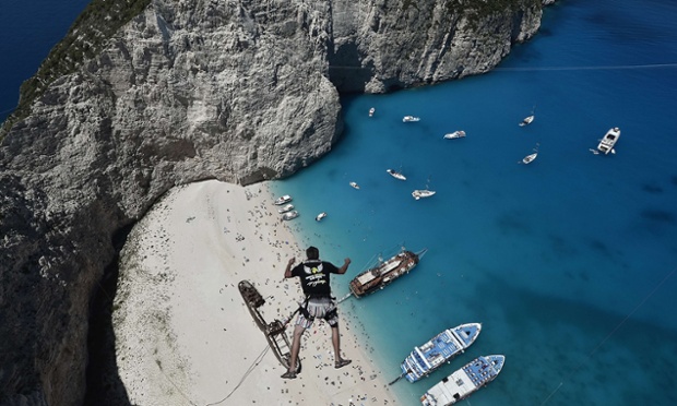 Lukas Michul, a member of the 'dream walker' group jumps from atop the rugged rocks overlooking the azure waters of Navagio beach, one of the Greece's most renowned leisure spots 