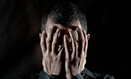 Depressed man with head in hands