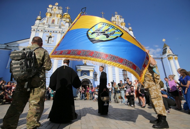 An orthodox priest prays with volunteers of the battalion 'Donbas' during a blessing ceremony in St. Michael Cathedral in Kiev, Ukraine.