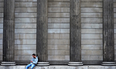 A man checks his phone outside the Bank